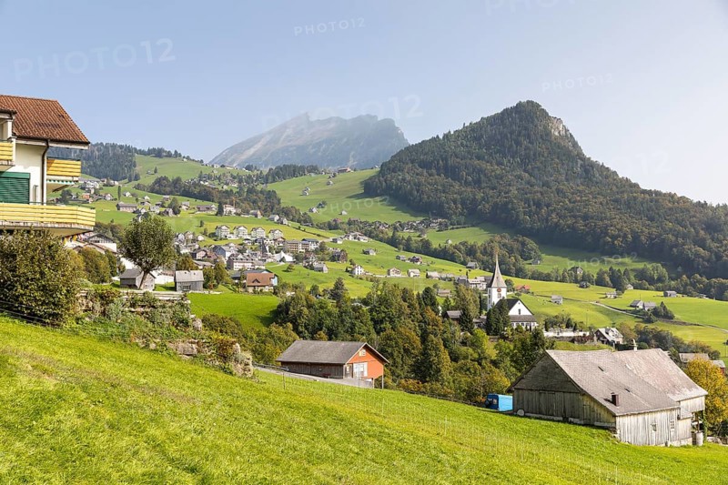 View of Amden with church and Chapf, in the background the Churfirsten mountain range with the Leistchamm, St. Gallen, Switzerland