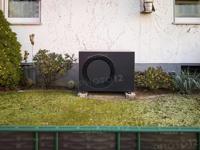 A black heat pump in a front garden in Langenfeld, Germany