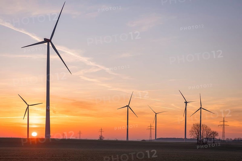Wind turbines in front of a colourful sunset on the horizon in an open landscape, near Ulm, Swabian Alb, Baden-Württemberg, Germany