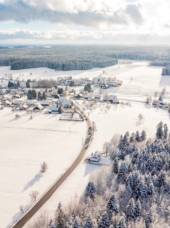 Snowy village with fields and trees, quiet winter atmosphere with sunny sky, Oberreichenbach, Black Forest, Calw district, Germany