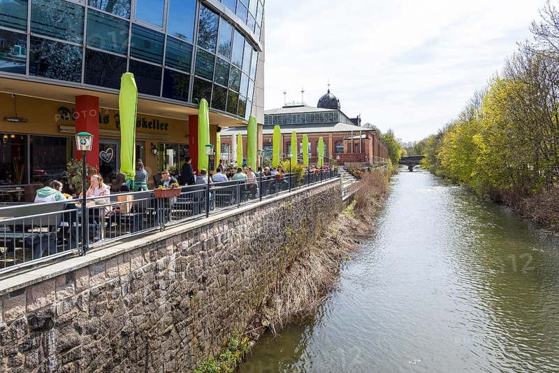 Outdoor area of a restaurant on the banks of the Chemnitz at Seeberplatz, in the background the market hall, Chemnitz, Saxony, Germany
