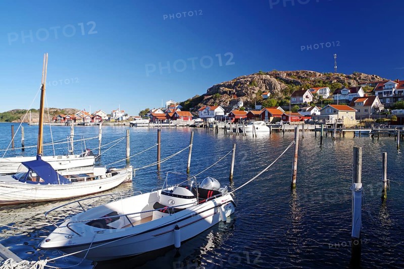 Small harbour with white boats and colourful houses on a sunny day, archipelago coast, Hamburgsund, Bohuslän, Sweden