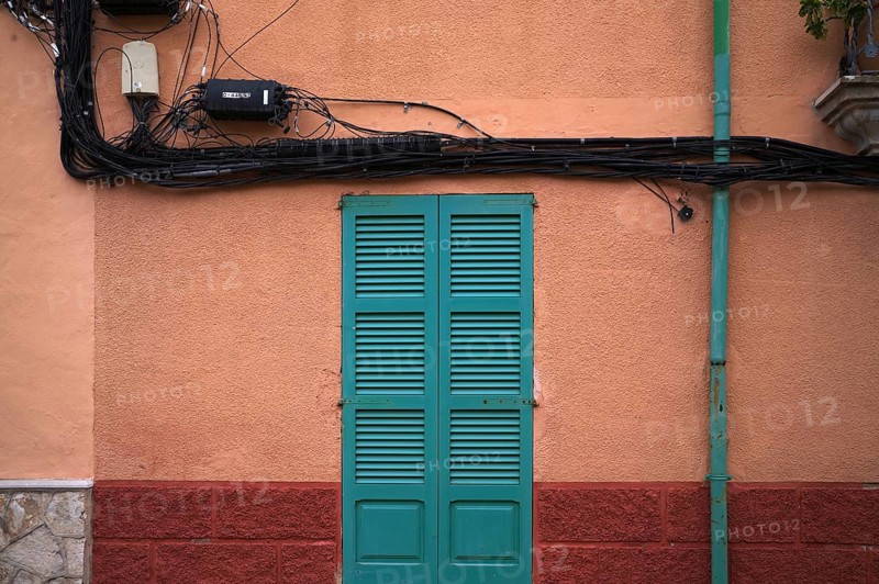 Power lines run outside the house wall, ochre-coloured, Alaró, Calvià, Majorca, Balearic Islands, Balearic Islands, Spain