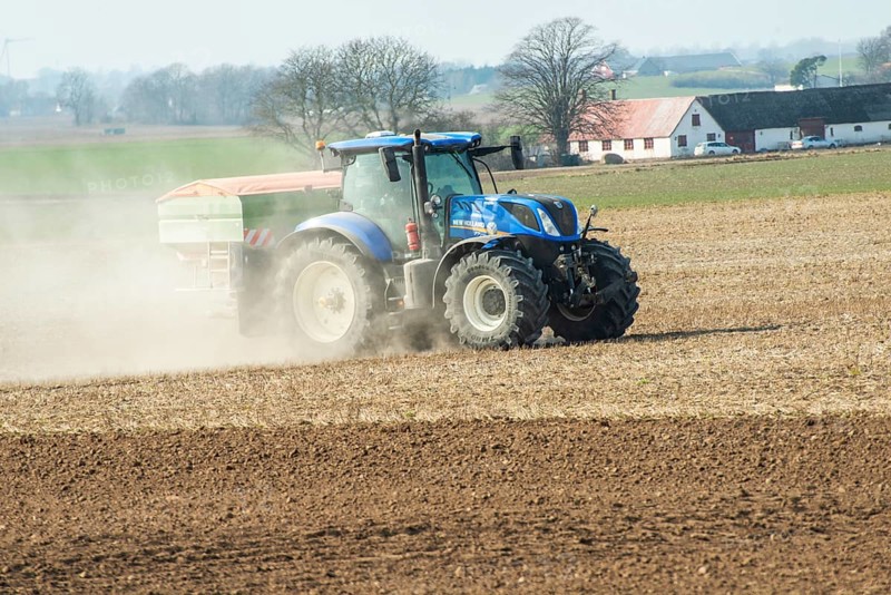 Spring farming, spreading fertilizer with tractor on field in Ystad municipality, Skåne county, Sweden, Scandinavia
