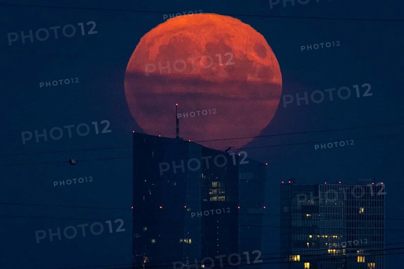 The full moon rises over the European Central Bank (ECB) in Frankfurt am Main, Frankfurt, Hesse, Germany