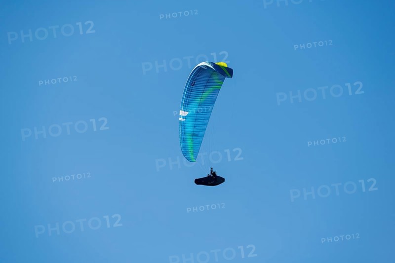 A paraglider soars through a clear blue sky that promises adventure and freedom, Schwangau near Füssen, Ostallgäu district, Swabia, Bavaria, Germany