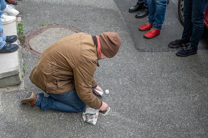 Pupil polishes and cleans a stumbling stone to commemorate the Night of Broken Glass on 9 November 1938, stumbling stone tour in Schnaittach, Middle Franconia, Bavaria, Germany