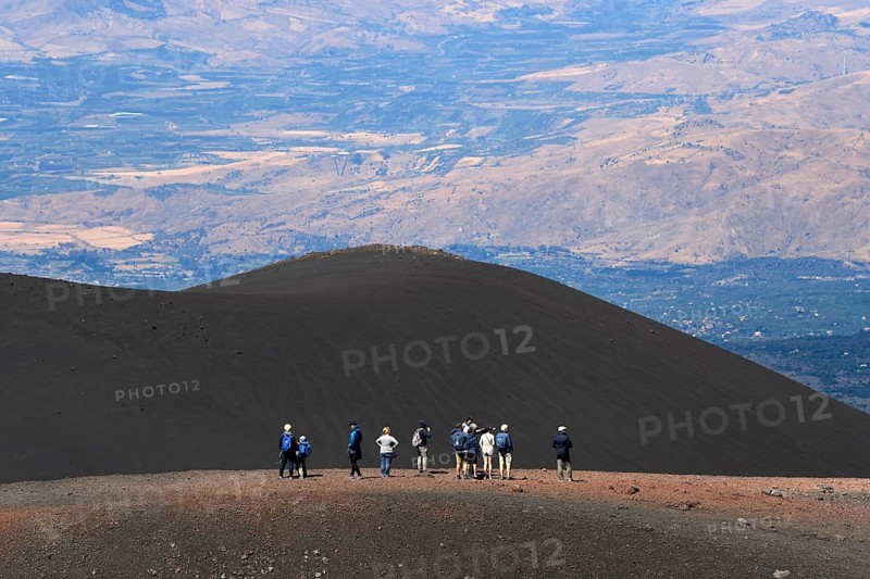 Hikers in the crater landscape of the volcano Etna, summit region, province of Catania, Sicily, Italy