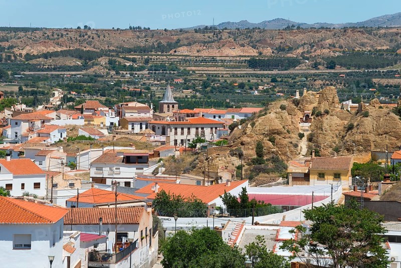 Panoramic view of a village with red roofs and mountains in the background under a clear sky, cave dwellings, cave district, Troglodytos, Barrio de Cuevas, Guadix, Granada province, Andalusia, Spain