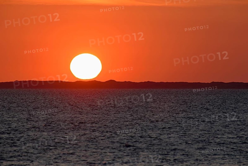 Sunset over the North Sea, on the horizon the contours of the island of Juist, Norddeich, Lower Saxony, Germany