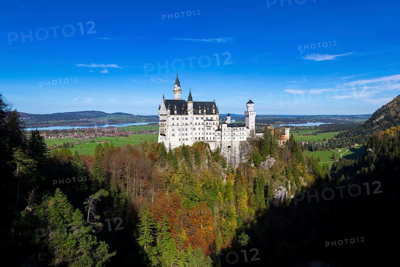 Panoramic view of Neuschwanstein surrounded by autumnal trees and mountains, Schwangau, Ostallgäu, Allgäu, Swabia, Upper Bavaria, Bavaria, Germany