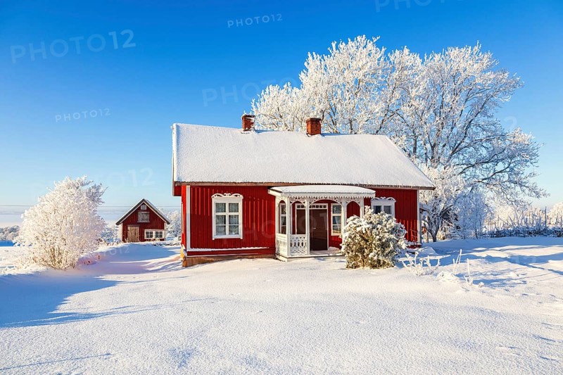 Idyllic old wooden red cottage a beautiful winter day with frosty trees and snow in the swedish countryside, Sweden