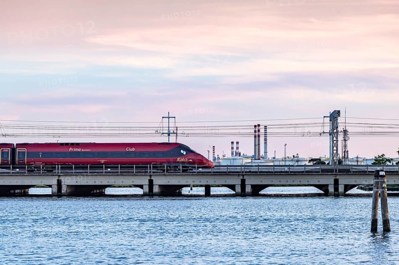 High-speed train operated by the private Italian railway company Italo. Ponte della Libertà, the bridge connecting Venice with the mainland. Venice, Venezia, Italy
