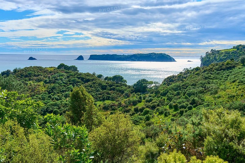 Panoramic view of the coast with green hills and islands in the sea, Cathedral Cove, Hahei, Coromandel Peninsula, North Island, New Zealand