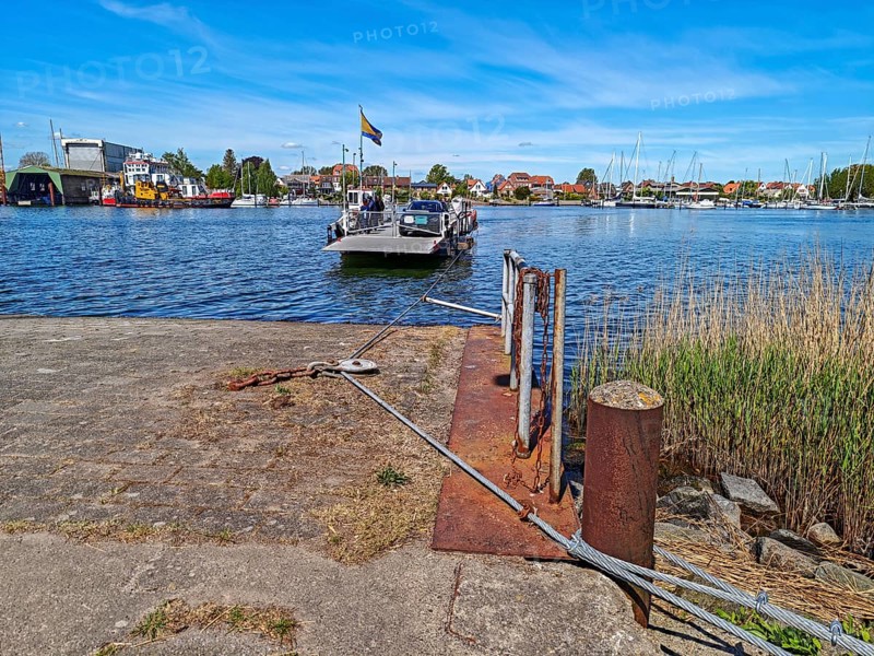 View of Germany's smallest town Arnis on the Schlei, grinding ferry, cable ferry for people and cars, wire ropes, transport technology, landing stage, shipyard, tugboat, marina with sailing boats, blue sky, sunshine, Sundsacker, Winnemark, landscape Schwansen, Schleswig-Holstein, Germany