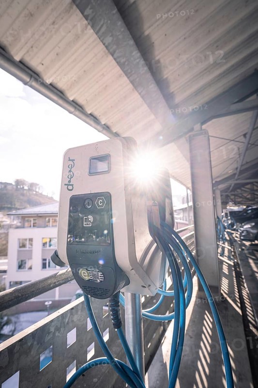 Electric charging station illuminated by sunlight, with blue cables, Kaufland Calw multi-storey car park, Calw district, Black Forest, Germany