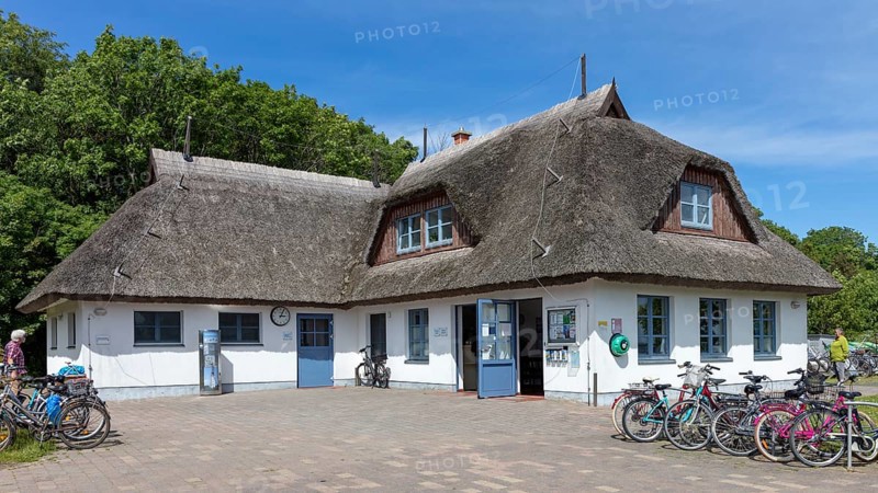 White, traditional thatched roof house with bicycles in front of it under a blue sky, Rügen, Hiddensee