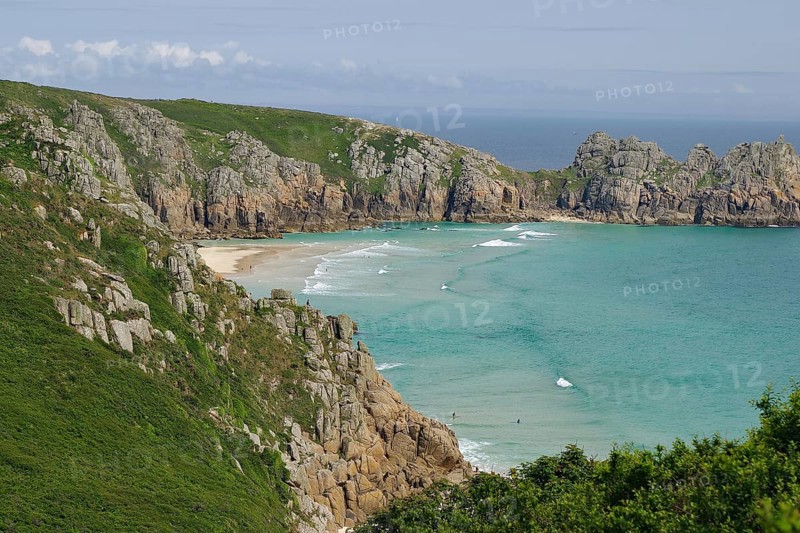 Felsen und Strand an einer Küste mit klarem Wasser und blauen Himmel, Porthcurno, St Levan, Cornwall, Großbritannien