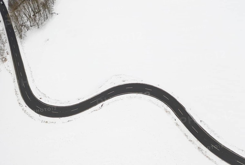 Aerial view of a winding country road in the snow, between Eppendorf and Leubsdorf, Central Saxony, Germany