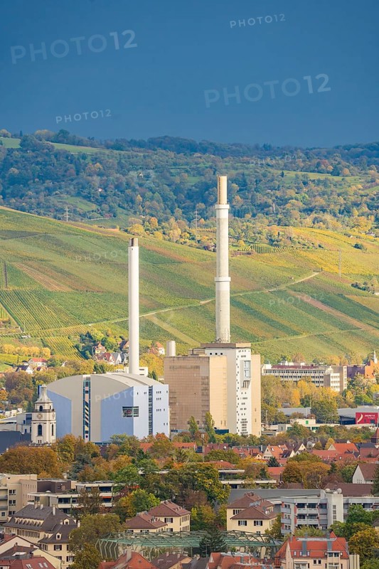 Industrial building with tall chimneys against an urban backdrop and clear sky, Stuttgart, Germany