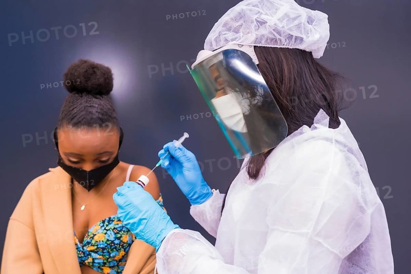 Black woman receiving the injection of the coronavirus vaccine by a doctor, antibodies, immunizes the population, people at risk, antibodies, new normal, covid-19