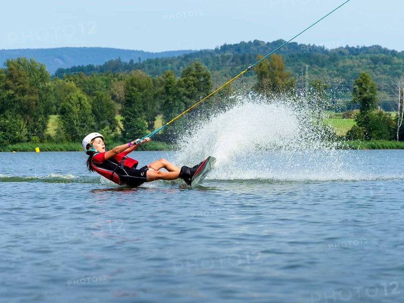 Boy or girl, summer holiday with wakeboard, water splashes, red life jacket, water skiing and wakepark, Stráž pod Ralskem, Czech Republic