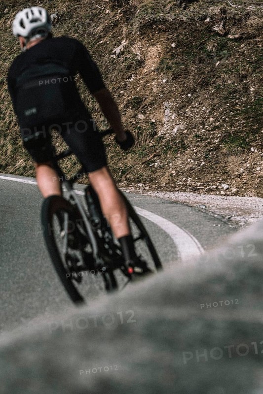 Road bike rider in spring between Lechtal and Tannheimer Tal in front of picturesque scenery of the Alps, Tyrol, Austria