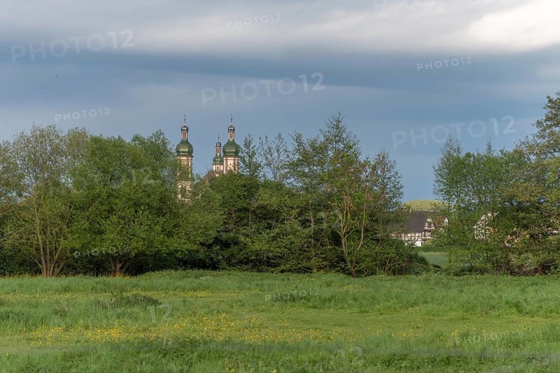 The baroque Saint-Maurice church in Ebersmunster surrounded by meadows in spring. Bas Rhin, Alsace, France