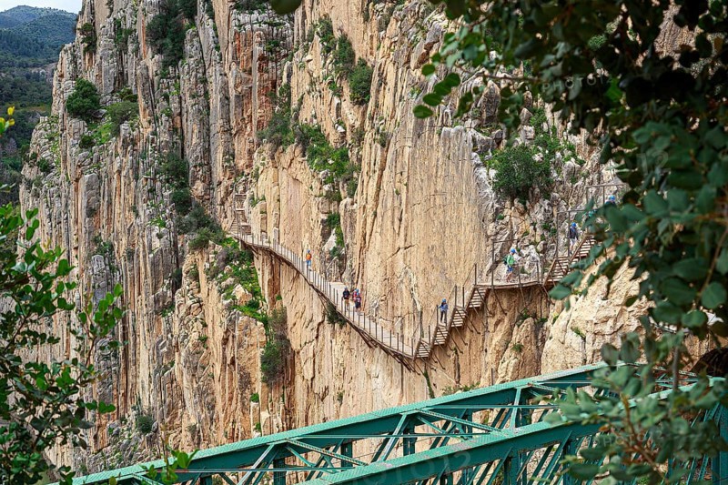 Wooden footbridge on a steep rock face in a gorge on the Caminito del Rey, Malaga, Spain