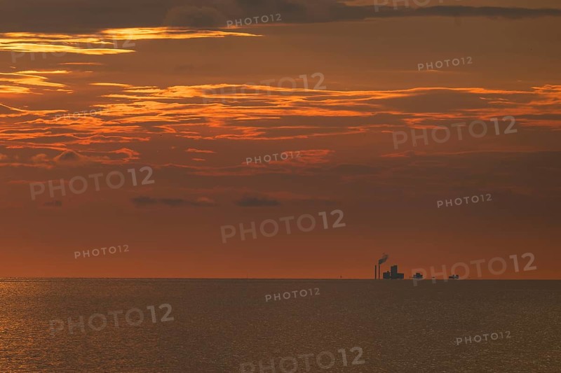 Factory on the horizon, sea surface, evening mood, Baltic Sea