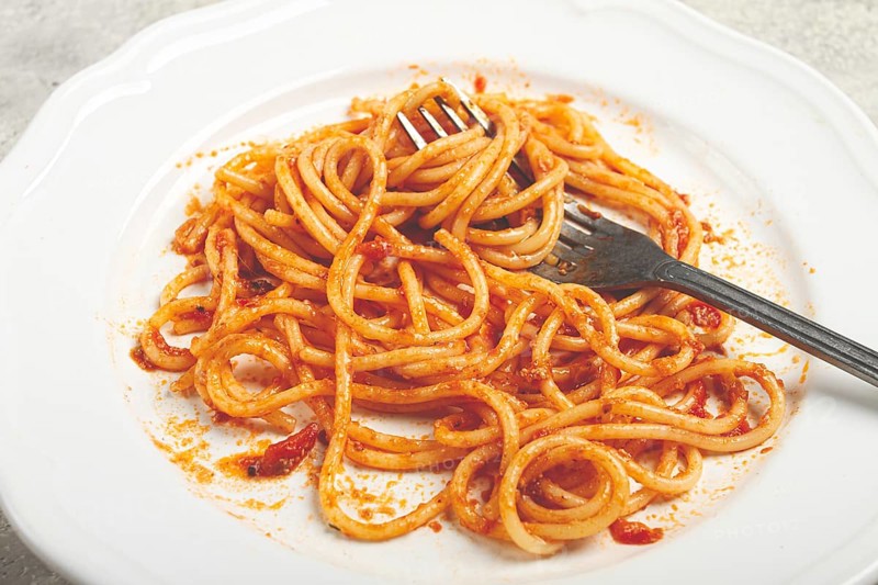 A plate with leftover spaghetti bolognese, no people