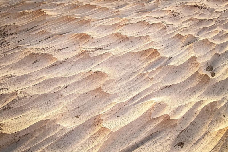 Fascinating texture of a pumice field in Catamarca, Argentina. The natural formations create a landscape of undulating waves and shadows under dim lighting
