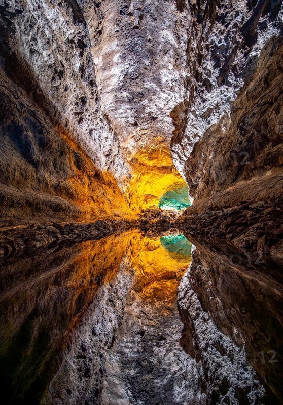 Lava tunnel, illuminated lava cave with perfect reflection in an underground lake, Cueva de los Verdes, Lanzarote, Canary Islands, Spain