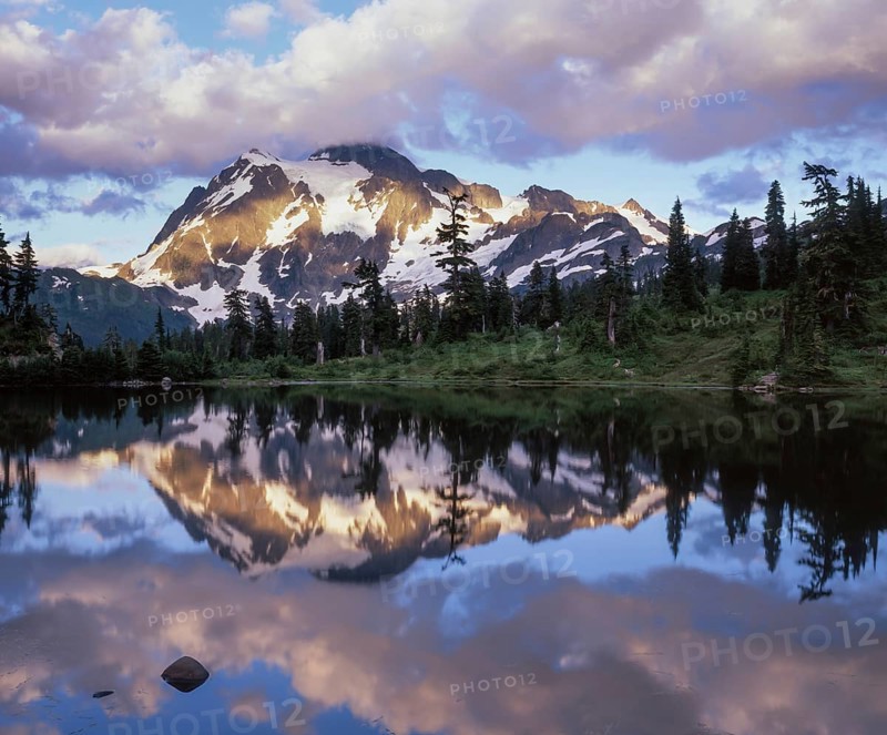 Twilight descends on Mount Shuksan in the North Cascades National Park as its snowy peak reflects beautifully in Picture Lake, creating a serene landscape
