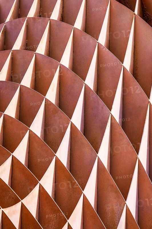Close-up of an abstract, rhythmic arrangement of alternating rusty and white metal fins forming a geometric pattern, located in Hong Kong
