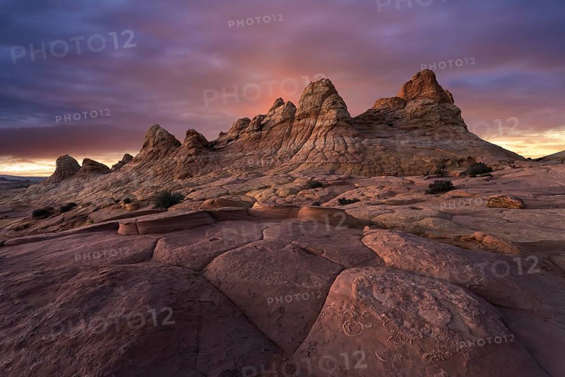 A majestic sunset casts warm colors over the unique sandstone formations at Coyote Buttes, located in the Paria Canyon-Vermilion Cliffs Wilderness, Arizona, USA