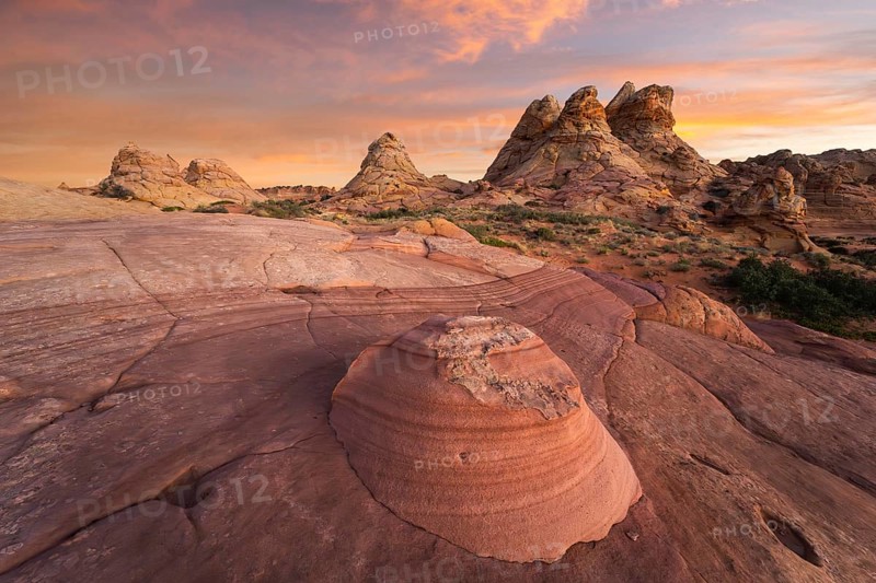 Golden sunset lighting the unique rock formations of Coyote Buttes in the Paria Canyon-Vermilion Cliffs Wilderness, Arizona, USA, highlighting the area's dramatic landscape