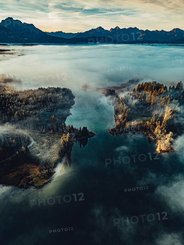 Autumn sunrise in the foothills of the Alps with fog at Illasbergsee and Forggensee near Halblech in Allgäu, Bavaria, Germany