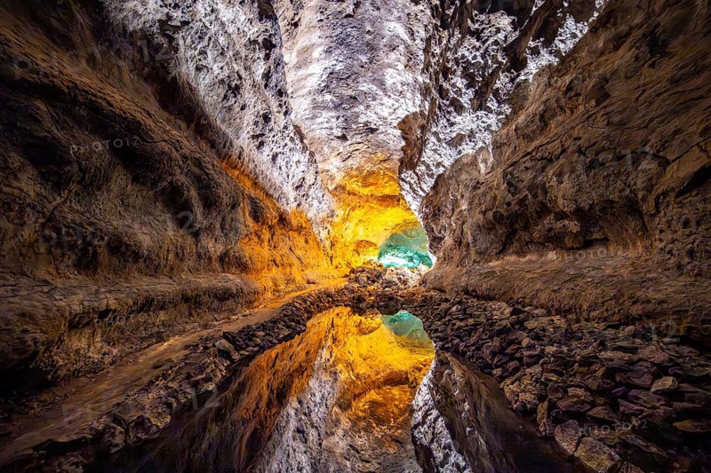 Lava tunnel, illuminated lava cave with perfect reflection in an underground lake, Cueva de los Verdes, Lanzarote, Canary Islands, Spain