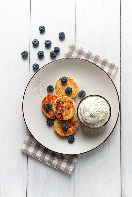 Cottage cheese pancakes, with blueberries, breakfast, on a white wooden table, no people, top view
