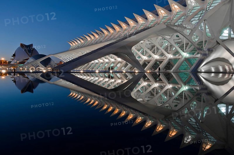 Stunning evening view of the City of Arts and Sciences in Valencia, Spain, showcasing its futuristic architecture and reflections in the serene water, illuminated against dusk
