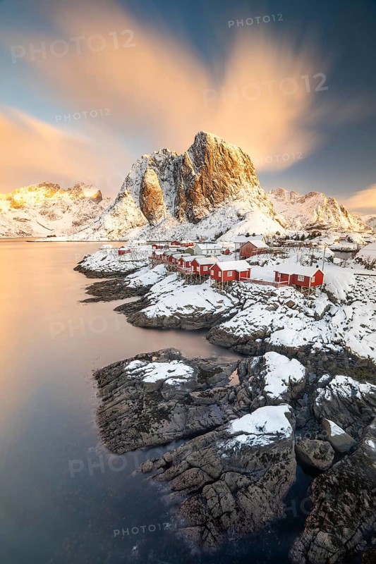 Rorbuer fishing huts in front of snow-covered mountains in winter, Hamnøy, Moskenesøy, Lofoten, Norway