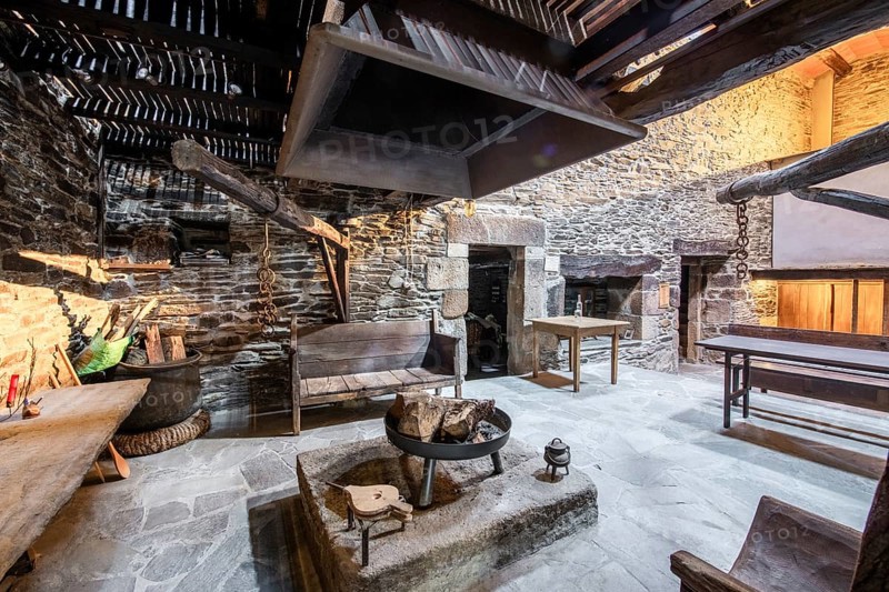 Traditional Lugo, Spain country house featuring rustic stone walls and a large open hearth in a historically preserved interior setting