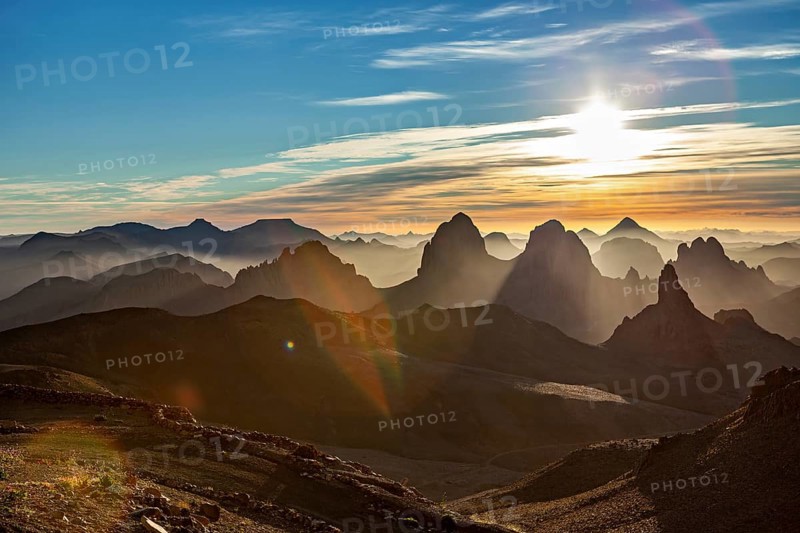 Sunbeams break through the haze over a mountain landscape at sunset, The landscape of the Ahaggar Mountains in the Sahara in Algeria