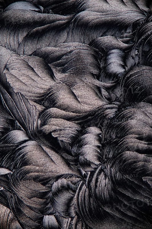 Magnified image showcasing the intricate details of salicylic acid microcrystals, depicted in a striking black and white contrast
