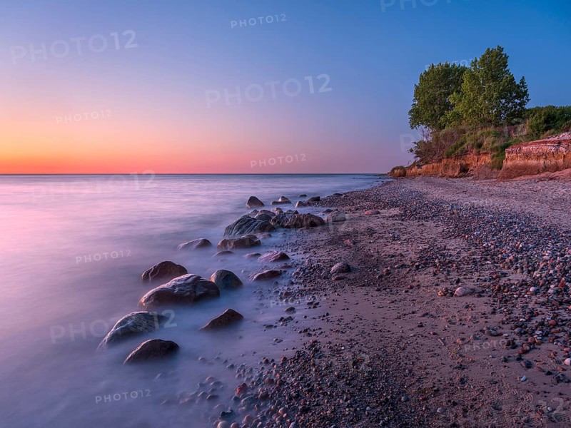 Unspoiled secluded stretch of coast with cliffs and boulders in the evening light on the Baltic Sea beach, near Rerik, Mecklenburg-Western Pomerania, Germany