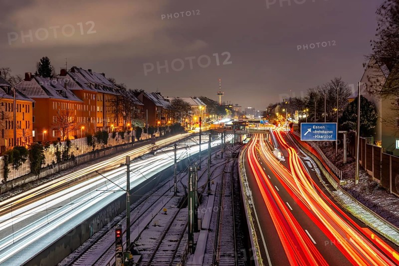 Autobahn A40, Ruhrschnellweg, near Essen at the Frohnhausen junction, evening traffic in winter, residential buildings directly on the 4-lane motorway, North Rhine-Westphalia, Germany