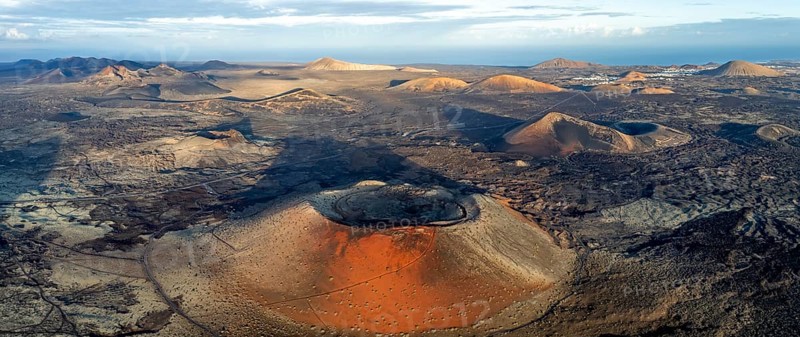 Caldera Colorada volcano, picturesque volcanic landscape with volcanic craters and lava fields in morning light, Parque Natural de Los Volcanes, aerial view, Lanzarote, Canary Islands, Spain