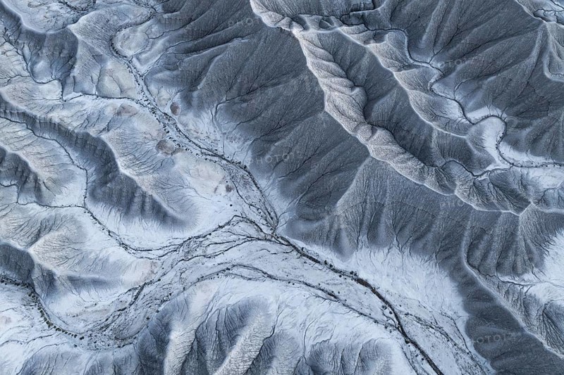 Aerial photograph showcasing the intricate textures and patterns of the eroded terrain near Hanksville, Utah, emphasizing the unique topography of Caineville Mesa