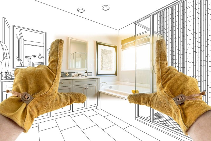 Male Contractor Hands Framing Completed Section of Bathroom Over Bathroom Drawing